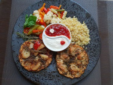 Na talerzu plastry pieczonego z tymiankiem i czoskiem selera podane z kaszą, warzywami i sosami