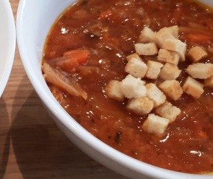 Zdjęcie przedstawia talerz flaczków z boczniaka posypanych grzankami