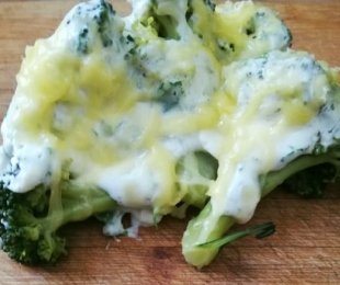 Na zdjęciu talerz, na nim brokuły zapiekane w serowo śmietanowym wegańskim sosie