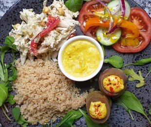 Na zdjęciu talerz, na nim Karczochy z sosem serowym podane z kaszą, warzywami i sosem