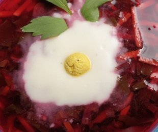 Zdjęcie przedstawia talerz chłodniku z botwinki ze śmietaną i wegańskim żółkiem