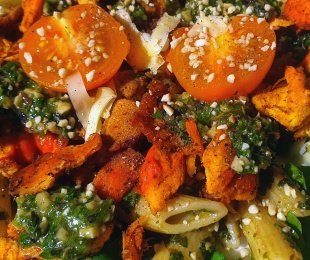 Na zdjęciu makaron penne z żółtą, pomidorkami i pesto bazyliowym