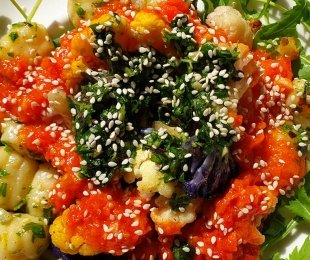 Na zdjęciu talerz, na nim makaron gnocchi z sosem, kalafiorem i pesto