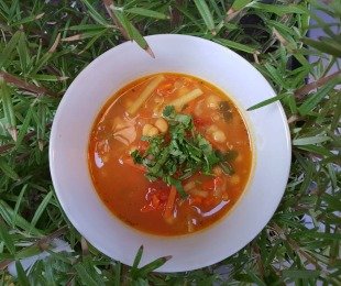 Zdjęcie przedstawia talerz zupy Curry Ciecierzycowe, posypanej świeżą kolendrą