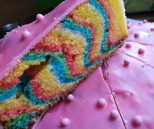 Zdjęcie przedstawia porcje kolorowego ciasta tęczowego